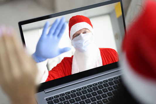 Un enfant parle au Père Noël en visioconférence, Père Noël masqué avec gants et bonnet rouge, moment tendre et connecté.